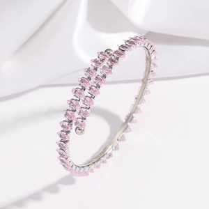 Gros plan du bracelet bypass argenté avec double rangée de zircons roses marquise