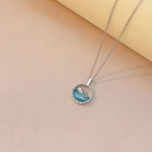 Minimalist whale pendant necklace with ocean blue resin wave on a silver chain