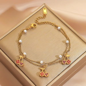 Double-layer gold bracelet with pearls and sparkling rhinestone cherry charms on silk