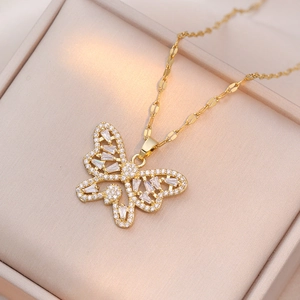 Elegante collana a farfalla dorata con cristalli su una scatola per gioielli color beige