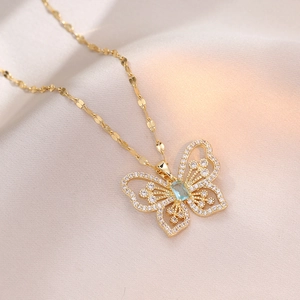 Collana a farfalla dorata con ali in zircone e pendente con gemma blu rettangolare
