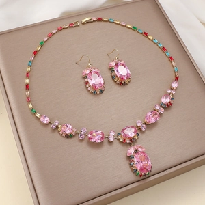 Pink floral jewelry set with zircon necklace and earrings on a gold display tray