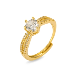 Détail d'une bague ajustable dorée avec zircon rond à six griffes et anneau pavé de cristaux