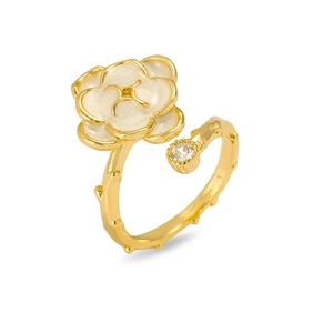 Detailed close-up of adjustable gold flower ring with white enamel and sparkling crystal