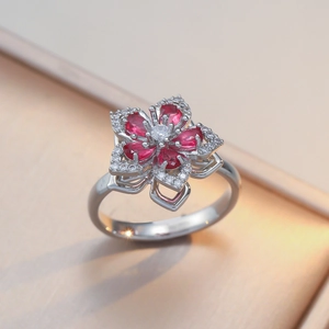 Rotating five-petal flower ring with red zircon crystals in silver-toned finish
