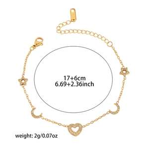 Détail d'un bracelet en acier titane doré avec pendentifs étoile, lune et cœur strass