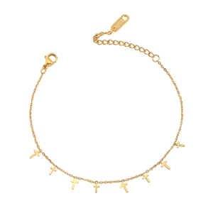 Vue détaillée du bracelet en acier inoxydable doré avec de petits pendentifs croix