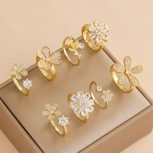 8-piece set of gold-plated floral rings with zirconia stones on a brown leather box