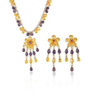 Golden sun-flower jewelry set with purple and yellow crystals on white background
