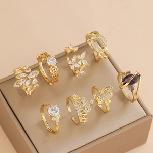 Set of 8 vintage gold flower rings with purple crystals in a beige jewelry display box