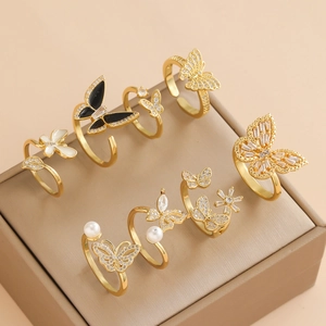 Gold butterfly ring set with pearls, shells, and zircons on a jewelry display
