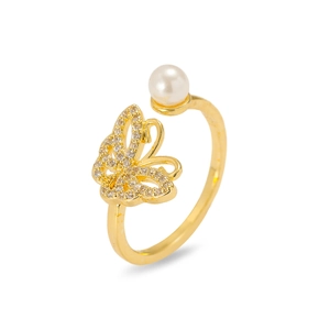 Detail of gold butterfly ring with sparkling zircons and a white round pearl