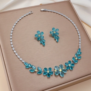 Detail of floral zircon necklace and earrings set on premium silk jewelry display