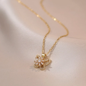 Macro shot of gold bow butterfly pendant necklace with zircon inlay on silk
