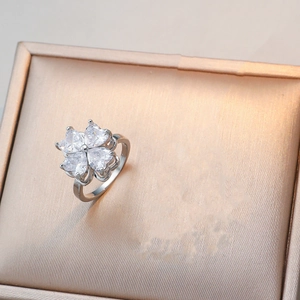 Bague trèfle en argent poli avec zircons en forme de cœur sur un écrin à bijoux or rose