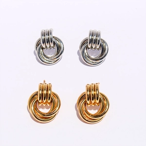 Vue détaillée des boucles d'oreilles nœud à double anneau en finitions or et argent poli