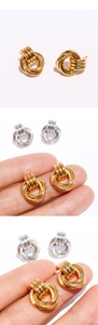 Vue macro des boucles d'oreilles nœud à trois anneaux polis en fini or et argent