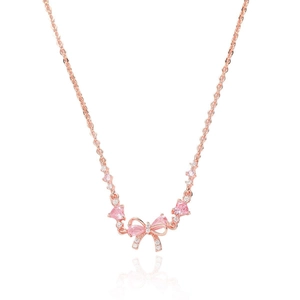Collier nœud en or rose avec pierres en cœur rose et pendentifs zircon sur fond blanc