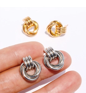 Détail de boucles d'oreilles géométriques à double boucle en doré et argenté