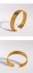 Primer plano de brazalete ancho dorado con detalles de textura de cadena tejida intrincada