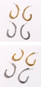 Détails macro de boucles d'oreilles créoles en U entrelacées en finitions or et argent