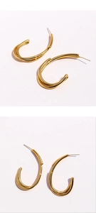 Vue détaillée de boucles d'oreilles en C dorées avec des lignes croisées et polies