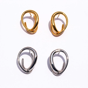 Detailed view of twisted geometric brass earrings in polished gold and silver finishes