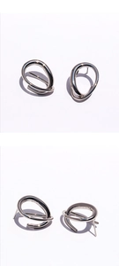 Macro detail of silver geometric earrings with polished abstract curved lines and studs