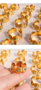 Détails d'une bague dorée vintage avec texture radiale et perles de turquoise