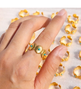 Détail de bague bohème dorée avec perles turquoise et motifs de relief de style vintage