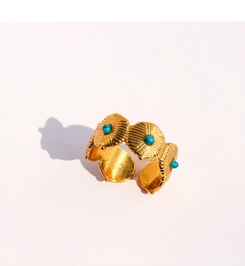 Détail de bague dorée ouverte avec disques en métal gaufré et turquoise incrusté