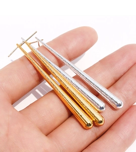 Détail de longues boucles d'oreilles goutte avec texture en métal martelé bicolore