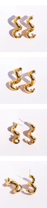 Vue macro des boucles d'oreilles spirales dorées avec finition miroir polie et courbes