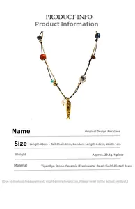 Dettaglio della collana in occhio di tigre e ceramica con ciondolo a pesce dorato e perle