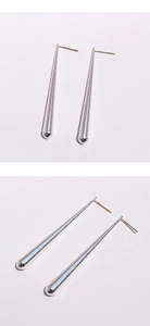Détail macro de boucles d'oreilles goutte argentées avec surface métallique martelée