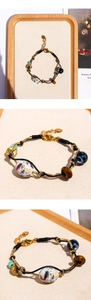 Dettaglio bracciale con occhio di tigre, perle di ceramica viola e cordino intrecciato