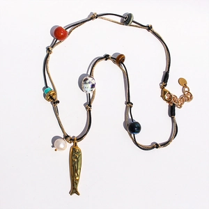 Dettaglio della collana occhio di tigre con ciondolo a pesce dorato e perline colorate