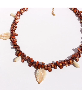 Detail of mother of pearl leaf pendants and brown beads on a vintage beaded necklace