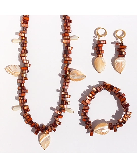 Detail view of brown shell beads and white carved leaf pendants on a jewelry set