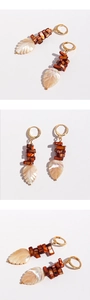 Detailed view of bohemian leaf earrings with natural shell and dark red beads
