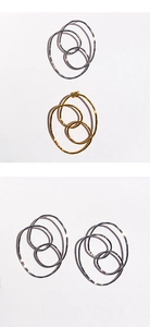 Gros plan sur des boucles d'oreilles anneaux en métal poli, finitions dorées et argentées