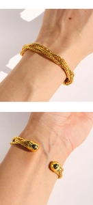Dettaglio del bracciale rigido a treccia in ottone dorato con terminali sferici al polso