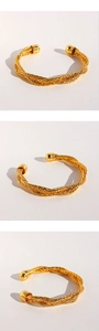 Dettaglio del bracciale a polsino intrecciato placcato oro con terminali a sfera in tre angoli