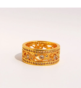 Gros plan sur une bague ajourée dorée à motifs de feuilles et pierres en zircone