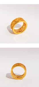 Détails macro du motif floral vintage sur une bague large dorée sertie de zircons brillants