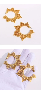 Detaillierte Nahaufnahme großer hohler C-förmiger Goldohrringe mit Blumenmuster-Gravur