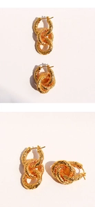 Détail macro de boucles d'oreilles dorées à trois anneaux avec texture martelée