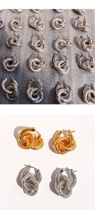 Détails macro de boucles d'oreilles créoles dorées et argentées à texture martelée