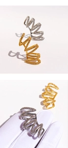 Détail de boucles d'oreilles multicouches dorées et argentées serties de zircons blancs