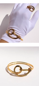 Close-up of golden nautical double knot bracelet and ring set with high-polish finish